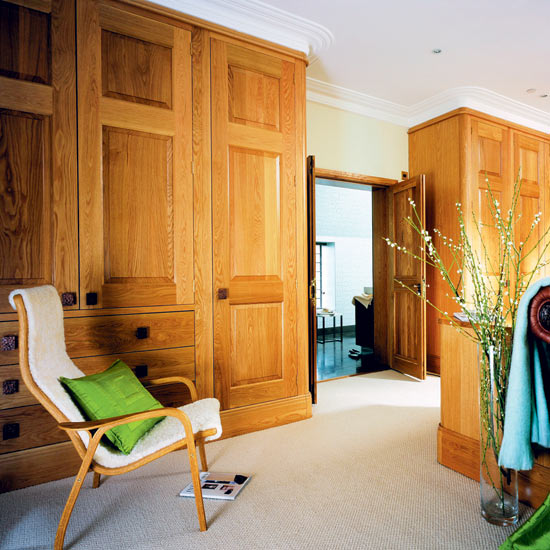 Here, the wood of the bathroom door matches that of the wardrobes for a smart look